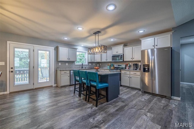 1541 Fairfield Dr, Lebanon, MO 65536 - kitchen with stainless steel appliances, dark wood finished floors, a breakfast bar area, baseboards, and recessed lighting