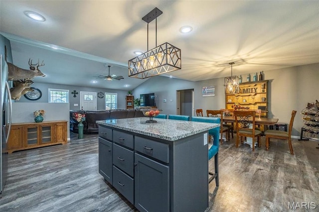 1541 Fairfield Dr, Lebanon, MO 65536 - kitchen with ceiling fan, a center island, a kitchen breakfast bar, dark wood-style floors, and lofted ceiling