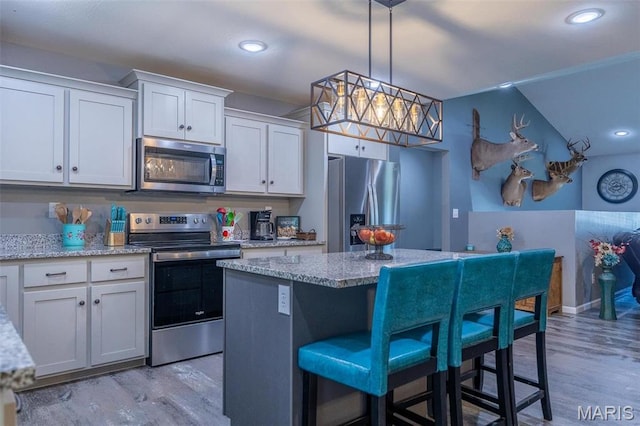 1541 Fairfield Dr, Lebanon, MO 65536 - kitchen featuring stainless steel appliances, light wood-style flooring, a breakfast bar, a kitchen island, and recessed lighting
