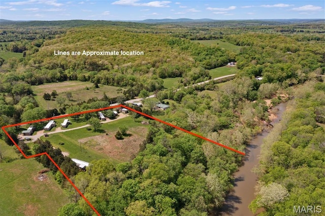 aerial view of property's location featuring a heavily wooded area and property parcel outlined