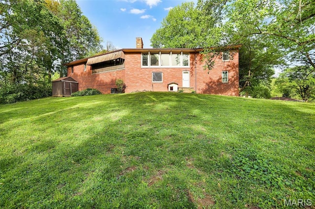 11 Wilshire St, East Alton, IL 62024 - back of house with a chimney, brick siding, and a lawn