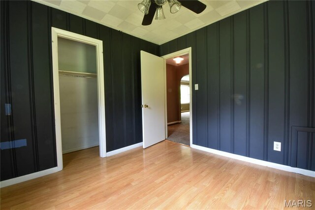 5007 Seiler Rd, Dorsey, IL 62021 - unfurnished bedroom with arched walkways, light wood-style flooring, baseboards, a closet, and a decorative wall