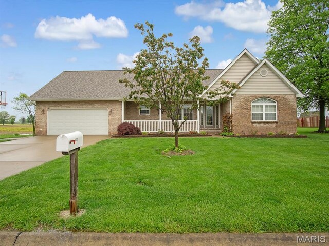 view of front of home with brick siding, a front yard, an attached garage, driveway, and a porch