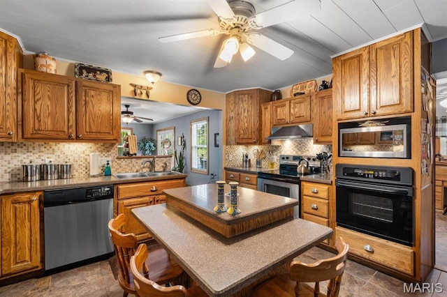 16785 County Road 624, Dexter, MO 63841 - kitchen with stainless steel appliances, a sink, under cabinet range hood, a ceiling fan, and a kitchen breakfast bar