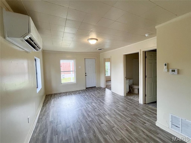 230 S Church St, Sullivan, MO 63080 - unfurnished living room with a wall mounted AC, plenty of natural light, baseboards, wood finished floors, and crown molding
