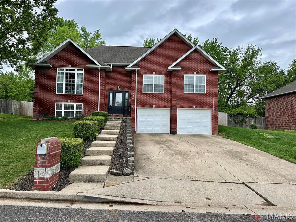 1324 Chelsea Ln, Rolla, MO 65401 - bi-level home featuring a garage, driveway, and brick siding
