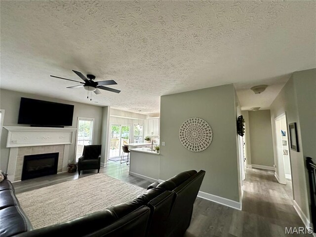1324 Chelsea Ln, Rolla, MO 65401 - living area with a ceiling fan, a fireplace, dark wood finished floors, baseboards, and a textured ceiling
