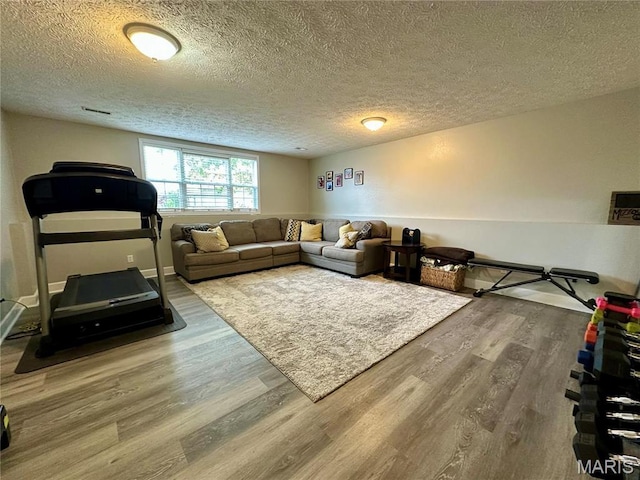 1324 Chelsea Ln, Rolla, MO 65401 - living area featuring wood finished floors, a textured ceiling, and baseboards