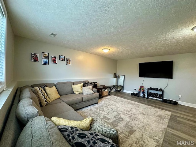 1324 Chelsea Ln, Rolla, MO 65401 - living area featuring a textured ceiling, wood finished floors, and baseboards
