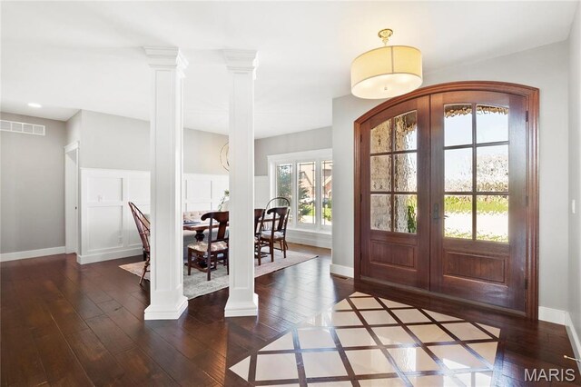 foyer entrance featuring french doors, wood-type flooring, baseboards, and decorative columns