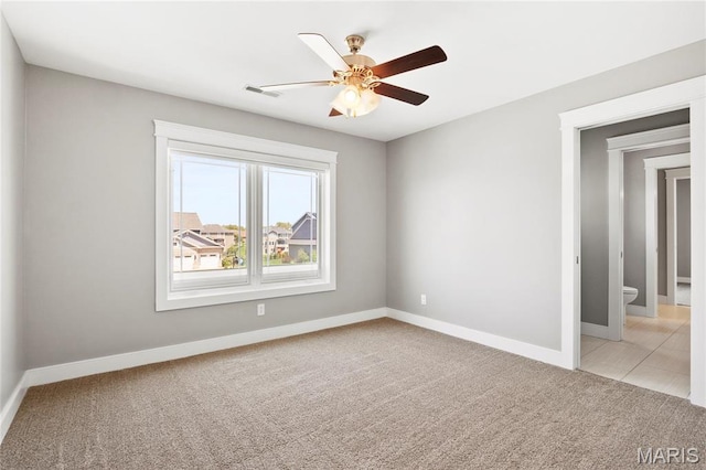 unfurnished room with ceiling fan, baseboards, and light colored carpet