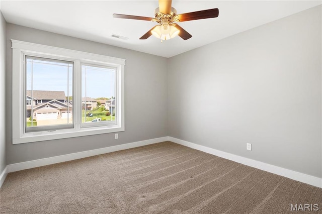carpeted spare room with baseboards and ceiling fan