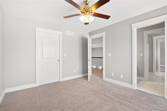 unfurnished bedroom featuring light carpet, baseboards, and a ceiling fan