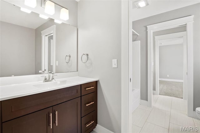 full bath featuring vanity and baseboards
