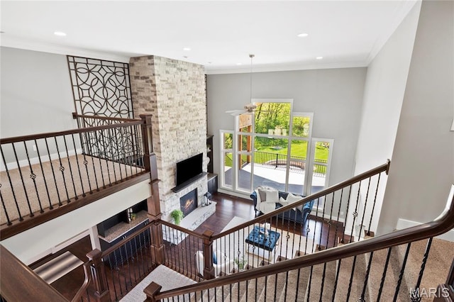 stairs with ceiling fan, a fireplace, ornamental molding, recessed lighting, and wood finished floors