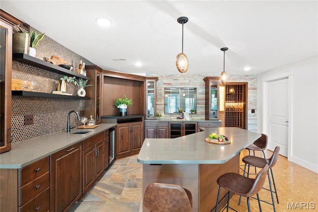 kitchen featuring open shelves, beverage cooler, a sink, a breakfast bar, and recessed lighting