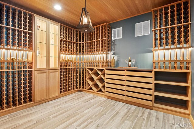 wine cellar with wooden ceiling, light wood-style floors, and recessed lighting