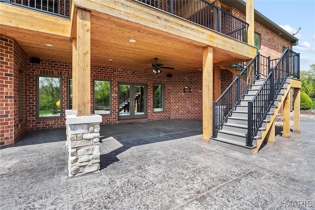 view of patio / terrace with ceiling fan, french doors, and stairway