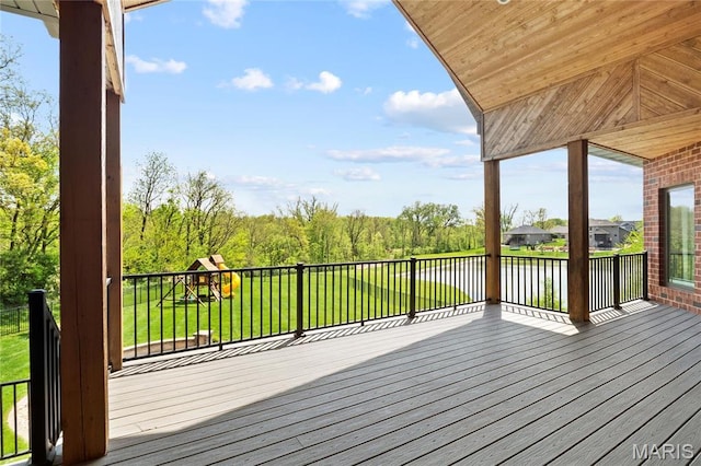 deck with a water view, a playground, and a lawn