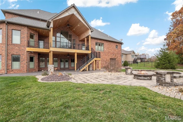 rear view of property featuring an outdoor fire pit, a patio area, brick siding, and ceiling fan