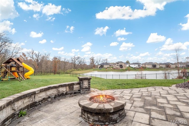 view of patio / terrace featuring a fire pit, a water view, a playground, and a residential view