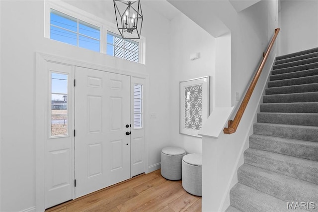 119 Monica Dr, Sunset Hills, MO 63127 - entrance foyer with wood finished floors, stairs, healthy amount of natural light, a chandelier, and a towering ceiling