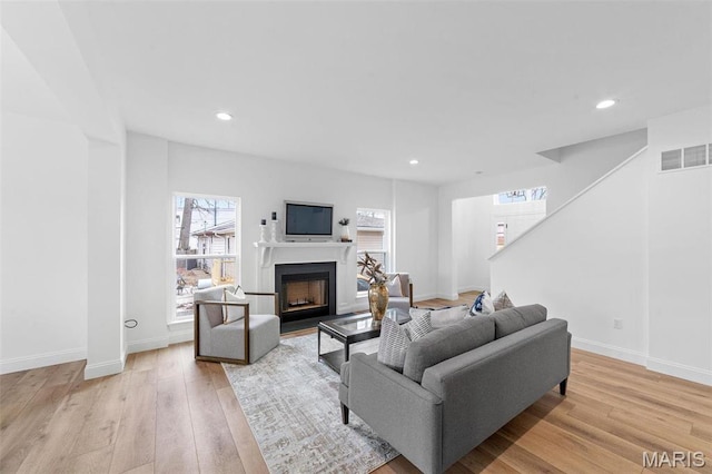 119 Monica Dr, Sunset Hills, MO 63127 - living area featuring light wood-type flooring, a fireplace with flush hearth, recessed lighting, baseboards, and stairway