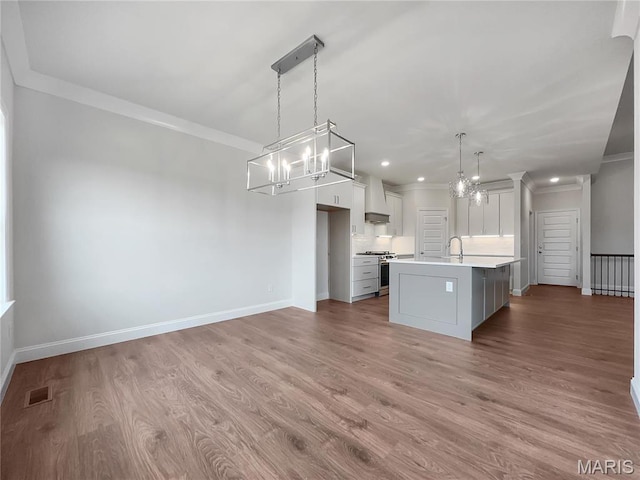 130 Stone Canyon Blvd, Foristell, MO 63348 - kitchen featuring stainless steel range, a chandelier, custom range hood, light countertops, and crown molding