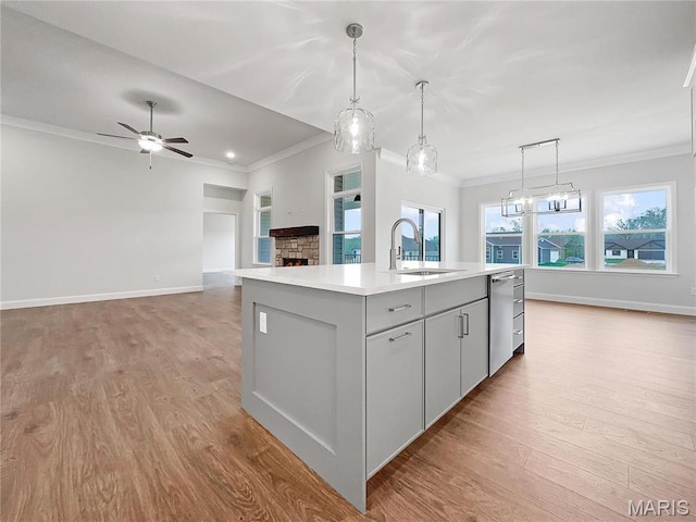 130 Stone Canyon Blvd, Foristell, MO 63348 - kitchen featuring stainless steel dishwasher, a sink, crown molding, an island with sink, and light wood finished floors