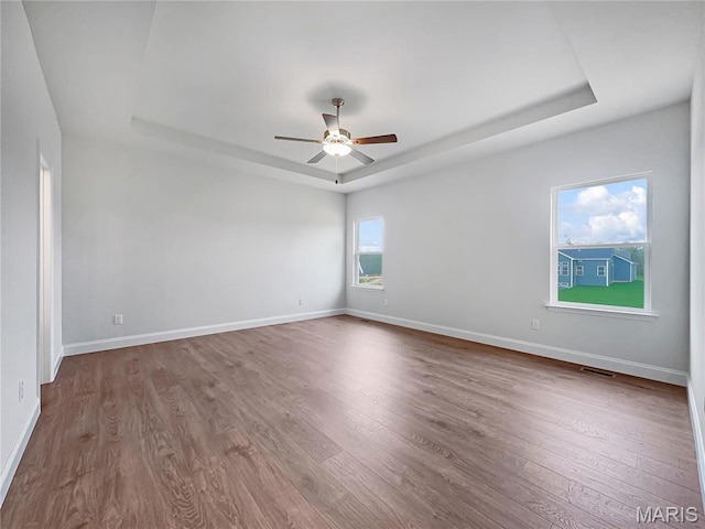 130 Stone Canyon Blvd, Foristell, MO 63348 - empty room featuring a tray ceiling, ceiling fan, dark wood finished floors, and baseboards