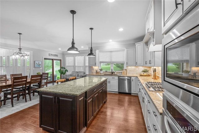 132 Hillary Cir, Wentzville, MO 63385 - kitchen with stainless steel appliances, a sink, ornamental molding, decorative backsplash, and dark wood finished floors