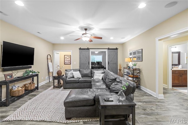 132 Hillary Cir, Wentzville, MO 63385 - living area with a barn door, wood finished floors, baseboards, ceiling fan, and recessed lighting