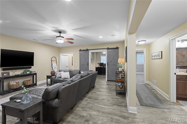 132 Hillary Cir, Wentzville, MO 63385 - living area featuring a barn door, a ceiling fan, light wood-type flooring, baseboards, and recessed lighting
