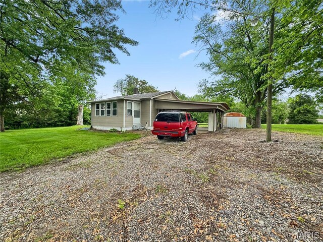 view of front of property featuring driveway, a front lawn, and a carport