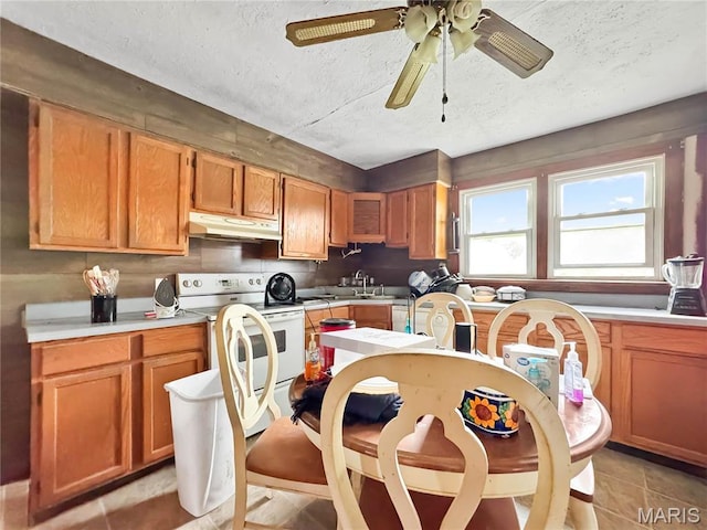 kitchen with under cabinet range hood, white electric range oven, a textured ceiling, light countertops, and a ceiling fan