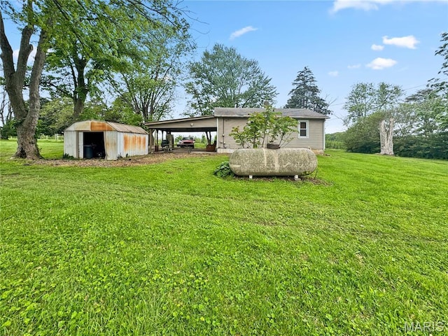 view of grassy yard with an outbuilding, a storage shed, and an attached carport