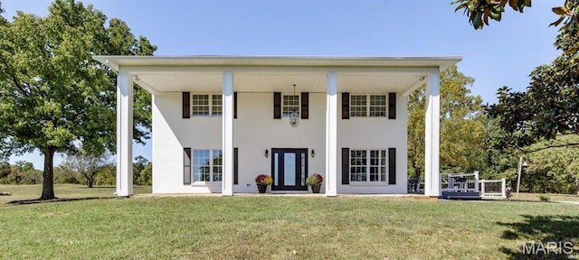 back of house with a yard and stucco siding
