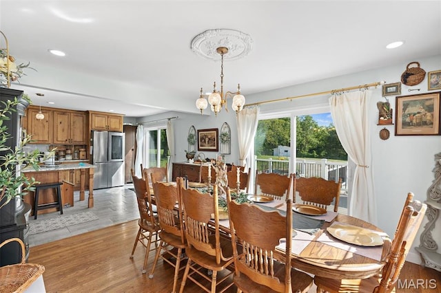 dining area featuring healthy amount of natural light, recessed lighting, light wood-type flooring, and a chandelier