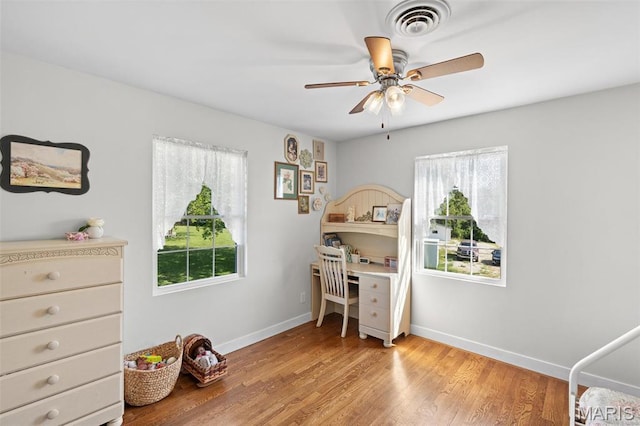bedroom featuring multiple windows, baseboards, light wood-type flooring, and ceiling fan