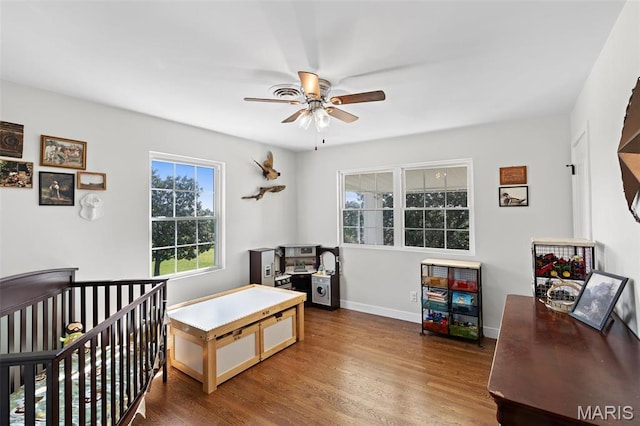 bedroom with wood finished floors, baseboards, a desk, and a ceiling fan