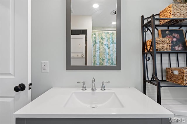 full bathroom featuring stacked washer / drying machine and vanity