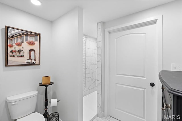 bathroom with a shower, toilet, and baseboards
