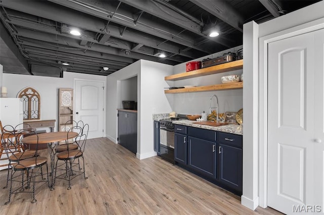 kitchen with a sink, blue cabinets, black gas range oven, light wood-style flooring, and open shelves