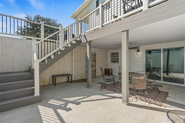 view of patio featuring stairway, outdoor dining space, and a balcony