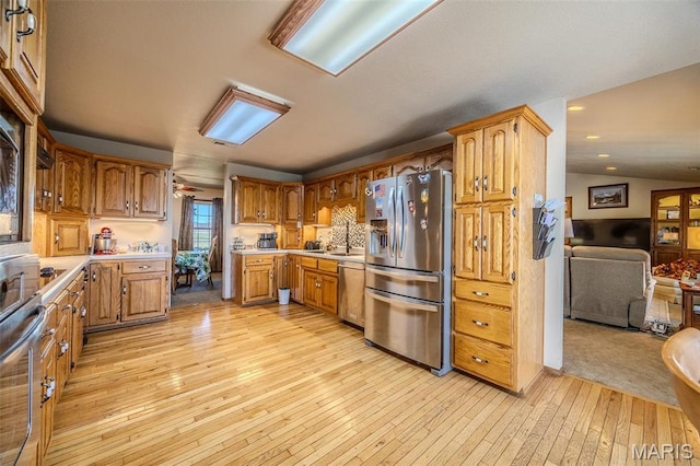23598 Falcon Rd, Lebanon, MO 65536 - kitchen with appliances with stainless steel finishes, light wood finished floors, a sink, light countertops, and open floor plan