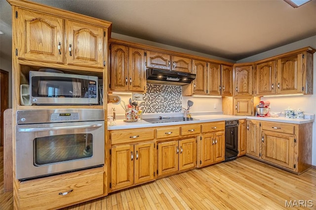 23598 Falcon Rd, Lebanon, MO 65536 - kitchen with stainless steel appliances, under cabinet range hood, light wood finished floors, brown cabinetry, and light countertops