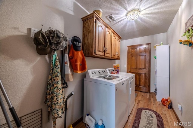 23598 Falcon Rd, Lebanon, MO 65536 - washroom with washer and dryer, light wood-type flooring, and cabinet space