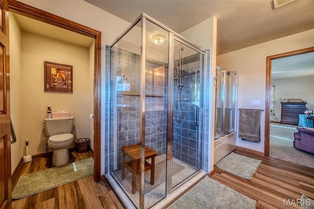 23598 Falcon Rd, Lebanon, MO 65536 - bathroom with wood finished floors, a stall shower, and toilet