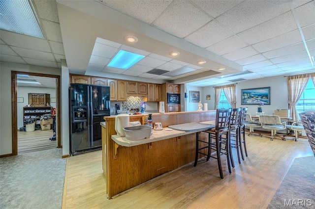 23598 Falcon Rd, Lebanon, MO 65536 - kitchen featuring black appliances, a drop ceiling, plenty of natural light, and a breakfast bar