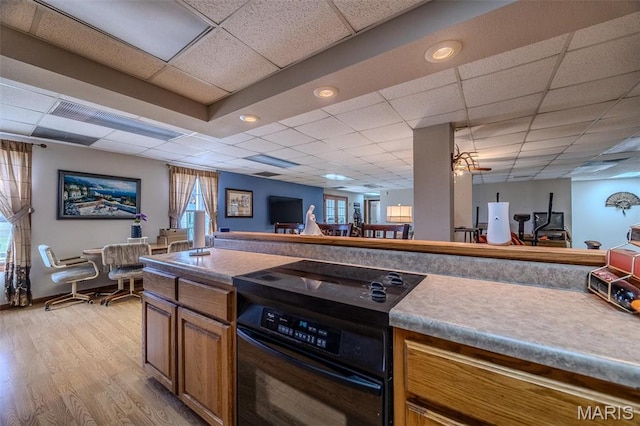 23598 Falcon Rd, Lebanon, MO 65536 - kitchen featuring range, a drop ceiling, light wood-style flooring, open floor plan, and brown cabinets